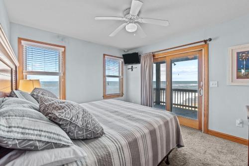 a bedroom with a bed with a view of the ocean at 7042 - Whistling Oyster by Resort Realty in Rodanthe