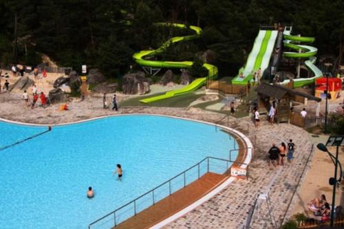 - un parc aquatique avec un toboggan et des personnes y séjournant dans l'établissement ARconciergerie Évasion en Pleine Nature, à Boigneville