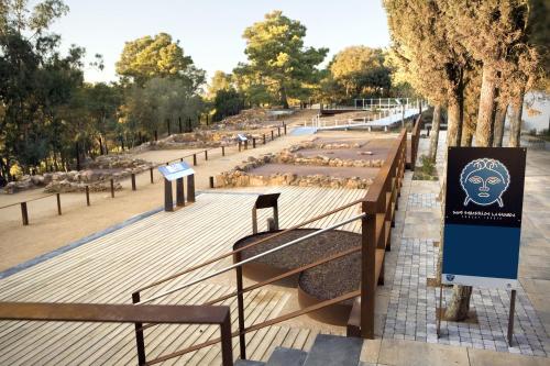 a park with benches and a sign with a head on it at El Far Hotel Restaurant in Llafranc