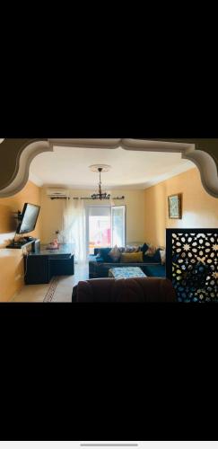 a living room with a couch and a table at Appartement résidence prive marina in Saidia 