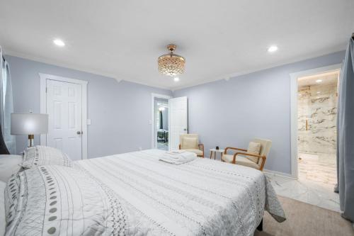 a white bedroom with a white bed and chairs at Gorgeous home in Lilburn in Lilburn