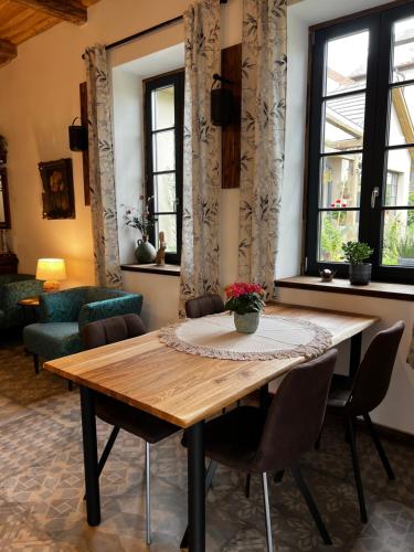 a dining room with a wooden table and chairs at Zöldkapu Vendégház in Balassagyarmat