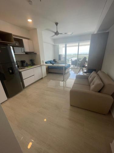 a living room with a couch and a kitchen at Cartagena Beach comodo y agradable Aparta Suite in Cartagena de Indias