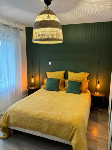 a bedroom with a large yellow bed with two lamps at L'esprit du quai in Boulogne-sur-Mer