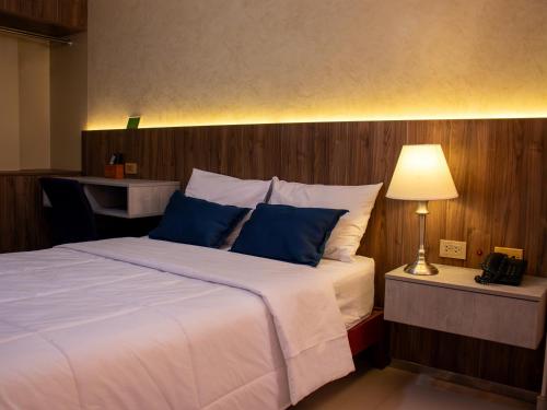 a bedroom with a large bed with blue pillows at Hotel America Chiclayo in Chiclayo