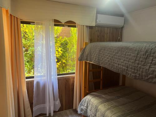 a bedroom with a bunk bed and a window at Departamento en Pucón Familiar para 7 personas vista Volcán Villarrica 4 dormitorios 3 baños in Pucón