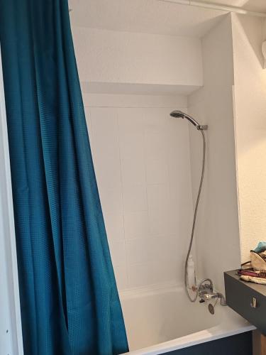 une douche avec un rideau de douche bleu dans une salle de bain dans l'établissement Appartement La Grande Motte, à La Grande Motte