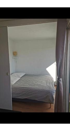 une chambre avec un lit dans une pièce avec une fenêtre dans l'établissement Appartement La Grande Motte, à La Grande Motte