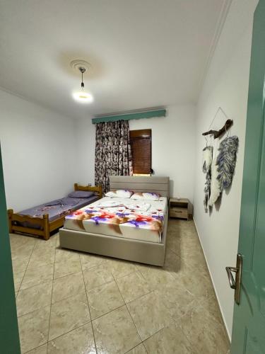 a bedroom with two beds and a window at Joen Apartment 3 in Sarandë