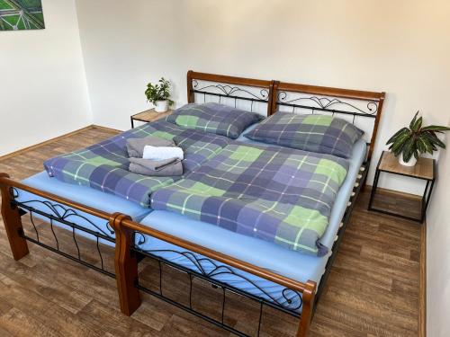 a bed with a blue and green comforter and pillows at Apartmány Bowling Frýdlant in Frýdlant