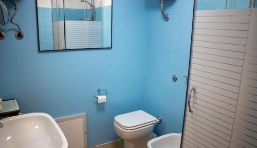 a bathroom with a toilet and a sink and a mirror at Sardinian Gallery Porto in Porto Alabe