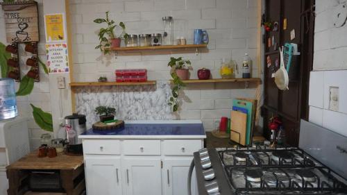 a kitchen with white cabinets and a blue counter top at Pool House Hostel in Santa Ana