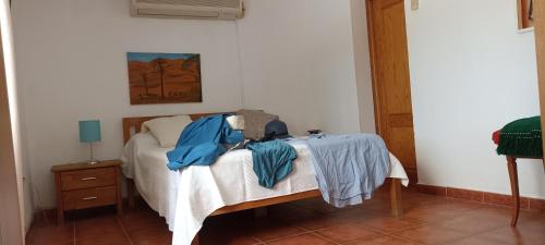 Un dormitorio con una cama con ropa azul. en Los Roblecillos en Pechina