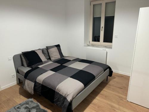 un lit dans une chambre blanche avec une fenêtre dans l'établissement Appartement IX - Haut Standing Proche Luxembourg et Cattenom, à Nilvange