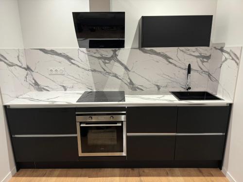 - une cuisine avec des comptoirs en marbre noir et blanc dans l'établissement Appartement IX - Haut Standing Proche Luxembourg et Cattenom, à Nilvange