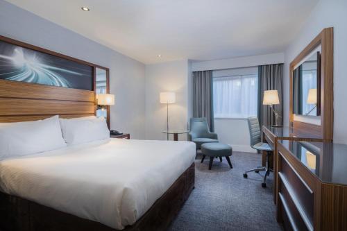 een hotelkamer met een bed en een bureau bij Ashford International Hotel & Spa in Ashford