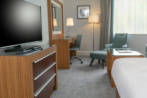 a hotel room with a flat screen tv and a bed at Ashford International Hotel & Spa in Ashford