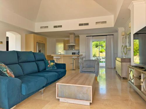 un soggiorno con divano blu e tavolo di Villa Los Olivos - Ole Solutions ad Arcos de la Frontera