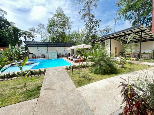 een huis met een zwembad in een tuin bij Villas Luna Africana by Palmer in Puerto Viejo