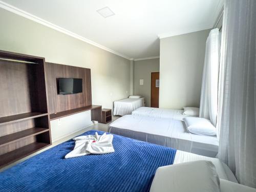 een hotelkamer met 2 bedden en handdoeken op het bed bij Dallas Hotel Premium in Altamira