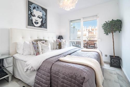 Un dormitorio con una cama grande y una ventana en PL- Beachfront seaview and frontline beach, en Mijas Costa
