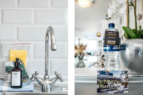 un fregadero con una botella de agua junto a un fregadero en PL- Beachfront seaview and frontline beach, en Mijas Costa