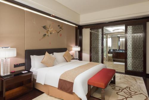 a bedroom with a large bed and a red bench at Crowne Plaza Chengdu Panda Garden by IHG-Near Panda Base in Chengdu