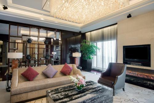 a living room with a couch and a tv at Crowne Plaza Chengdu Panda Garden by IHG-Near Panda Base in Chengdu