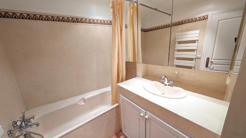 une salle de bain avec un lavabo et une baignoire dans l'établissement Ref ILES - Palmes d'Or Properties, à Cannes