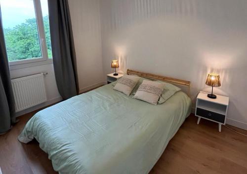 une chambre avec un lit avec deux lampes sur deux tables dans l'établissement Le Montreuillois ! Parking privé et Métro à proximité, à Montreuil
