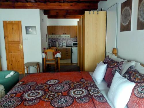 a bedroom with a large bed and a kitchen at Pension Archa in Znojmo