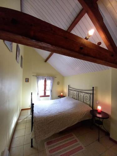 une chambre avec un grand lit dans un grenier dans l'établissement Charmant gîte au cœur de la nature et des animaux, à Saint-Hilaire-de-Riez