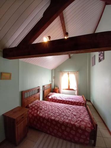 - une chambre mansardée avec 2 lits et une fenêtre dans l'établissement Charmant gîte au cœur de la nature et des animaux, à Saint-Hilaire-de-Riez
