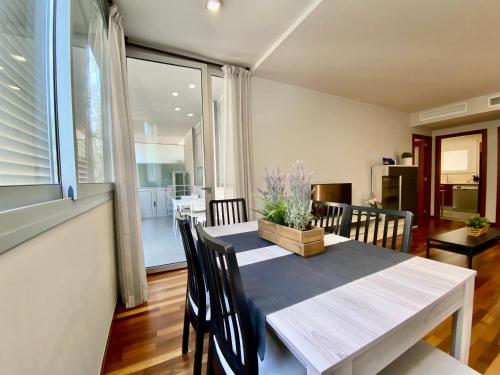 uma sala de jantar com mesa e cadeiras e uma cozinha em Carmed Homely Apartment by HLCLUB Agency em Vilanova i la Geltrú