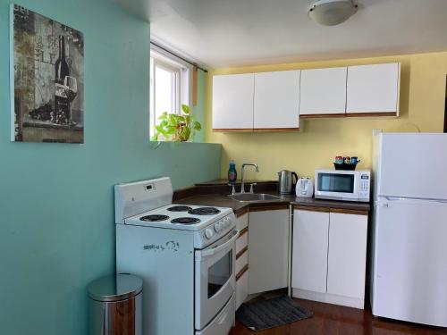 a kitchen with a stove and a white refrigerator at Ozone Homes-Private Basement Unit in Halifax