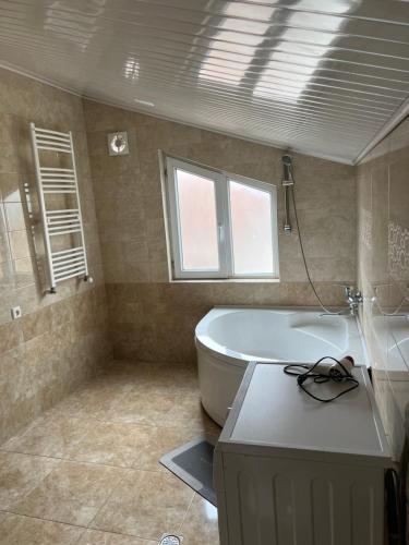 a bathroom with a tub and a toilet and a window at Guesthouse Emilya in Kutaisi