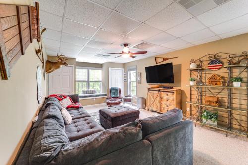 a living room with a large couch and a flat screen tv at 9 Mi to Sugar Mountain Newland Cabin with Fire Pit! in Newland