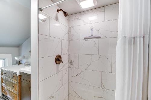 a bathroom with a shower with white marble tiles at Montour Falls Home 2 Mi to Seneca Lake and Wineries in Montour Falls