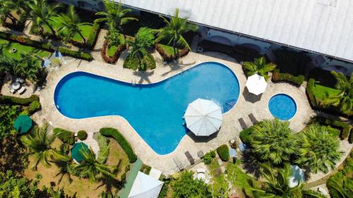 einen Blick über den Pool eines Resorts in der Unterkunft Poolside Oasis near Manuel Antonio! AC/WiFi/Tennis in Quepos