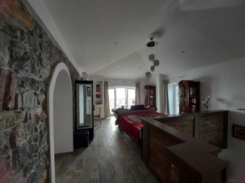 a living room with a bed and a stone wall at Apartment Trieste M&M in Muggia