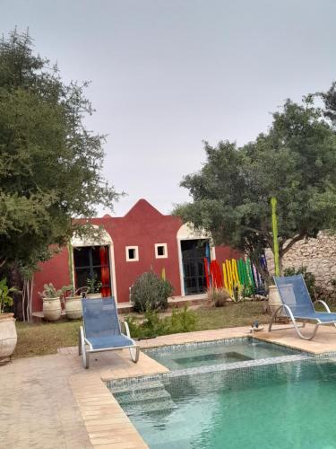 two chairs and a swimming pool in front of a house at TARGANINE Lodge in Essaouira