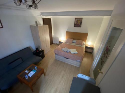 a small bedroom with a bed and a couch at Hostel Penedes in Vilafranca del Penedès