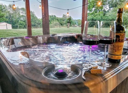 bañera de hidromasaje con 2 copas de vino en Hot Tub - Home Gym - Fire Pit - Game Room - Private Footpath to Winery, en Delaplane
