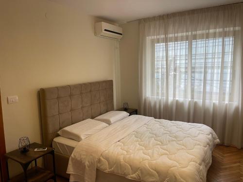 ein Schlafzimmer mit einem großen Bett und einem Fenster in der Unterkunft Cozy Apartment, in the center of Tirana in Tirana