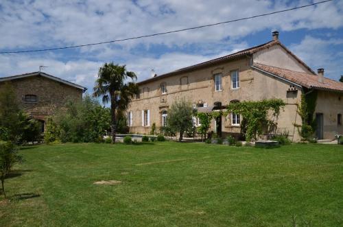 een groot gebouw met een tuin ervoor bij ferme st pierre suite, piscine, clim, repas, cheminée in Chabeuil