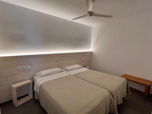 a bedroom with two beds and a ceiling fan at Hostal ROM Familiar in Roses