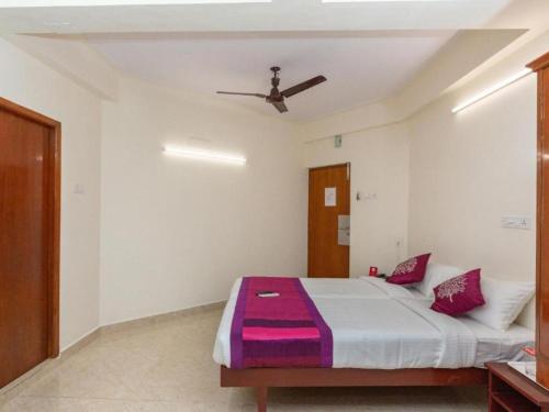 a bedroom with a bed with a ceiling fan at Mylooran Hotel in Jaffna
