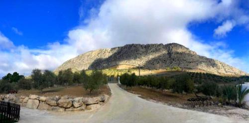 a dirt road in front of a mountain at Casa rural Rocío - Caminito del Rey in Valle de Abdalagís