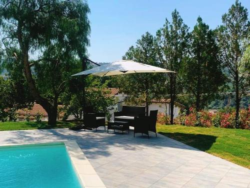 un tavolo e sedie sotto un ombrellone accanto alla piscina di Case vacanza Cilentane a Giungano