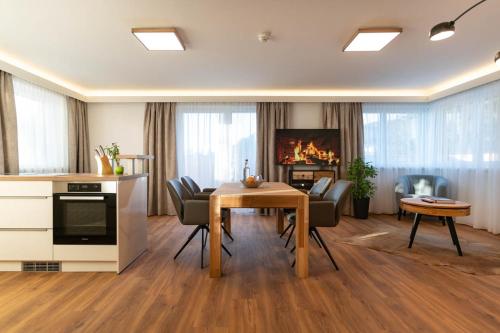 a kitchen and living room with a table and chairs at Waldrand Apartments in Ramsau am Dachstein